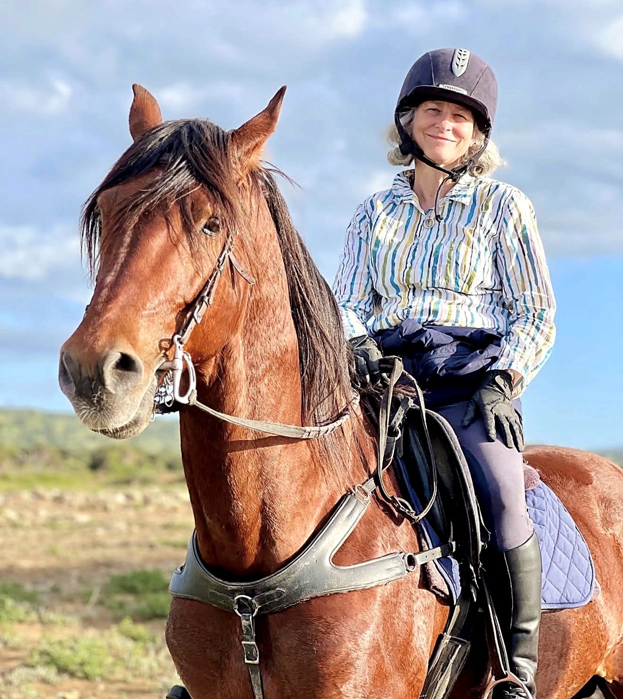 Une cavalière souriante sur un cheval alezan